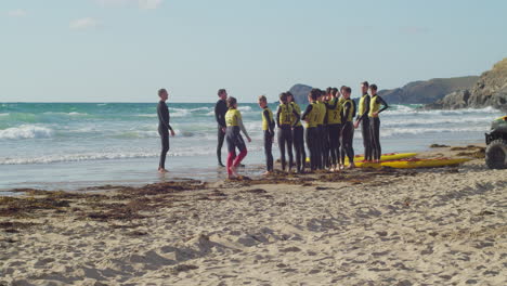 Un-Grupo-De-Jóvenes-Jóvenes-Se-Reunió-En-La-Playa-De-Perranporth-Practicando-Con-Su-Maestro-Para-Salvar-A-La-Gente-En-El-Mar-En-Cornwall.