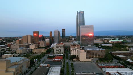 Vista-Aérea-Hacia-Un-Rascacielos-En-El-Centro-De-La-Ciudad-De-Oklahoma-Iluminada-Por-La-Puesta-De-Sol---Acercándose,-Disparo-De-Drones