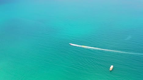 Luftaufnahme-Eines-Einzelnen-Einsamen-Bananenboots,-Das-An-Einem-Heißen-Sommertag-Mit-Touristen-Auf-Dem-Mittelmeer-Der-Türkei-Gezogen-Wird