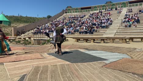 Mittelalterlicher-Arabischer-Schauspieler-In-Einer-Open-Air-Performance-Mit-Einem-Sekretärsvogel,-Der-Auf-Eine-Gefälschte-Schlange-Tritt