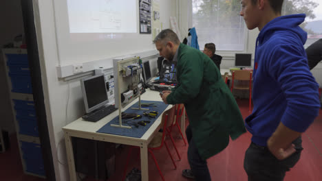 Lehrer-Hilft-Jungen-Männlichen-Schülern-Bei-Einem-Projekt-Im-Elektronikunterricht-An-Der-Berufsoberschule-In-Der-Slowakei