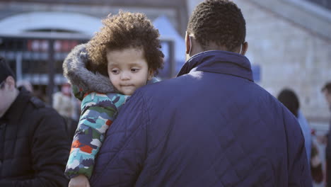 The-man-holds-a-kid-on-his-shoulder-while-standing-in-queue-up-at-the-registration-center-on-the-National-Stadium-in-Warsaw-to-receive-a-Polish-social-security-number