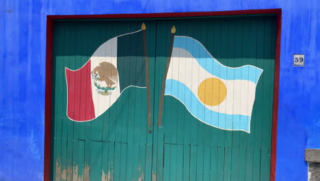 Banderas-Mexicanas-Y-Argentinas-Pintadas-En-Puertas-De-Madera-Verde-En-La-Famosa-Casa-Azul-Del-Museo-Frida-Kahlo