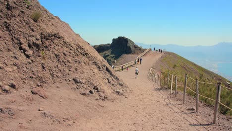 Panorámica-A-Través-Del-Camino-Y-Gente-Caminando-A-Lo-Largo-Del-Cráter-Del-Volcán-Monte-Vesubio-Cerca-De-Pompeya,-Italia