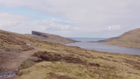 Wide-Pan-Right-of-the-Lake-Above-the-Ocean-and-Cliffside-in-the-Faroe-Islands