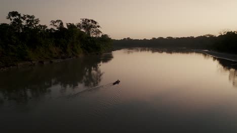 Siluetas-De-Bosque-Reflejadas-En-El-Idílico-Río-Amazonas-Con-Persona-Navegando-Durante-La-Puesta-De-Sol