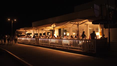 La-Gente-Cena-En-Un-Restaurante-Italiano-Junto-A-Los-Canales-Por-La-Noche-En-Cesenatico,-Italia