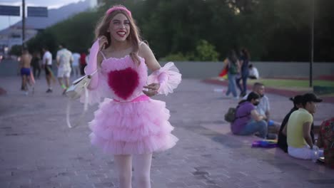 A-smiling-girl-wearing-a-pink-dress-carrying-her-hand-bag-walking-on-the-street