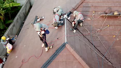 Asiatischer-Techniker-Arbeitet-An-Dachmontage,-Luftaufnahme