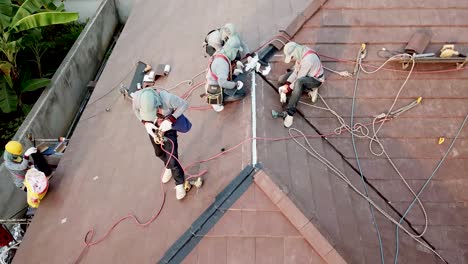 Asian-Technician-Work-on-Roof-Installation,-Aerial-Shot