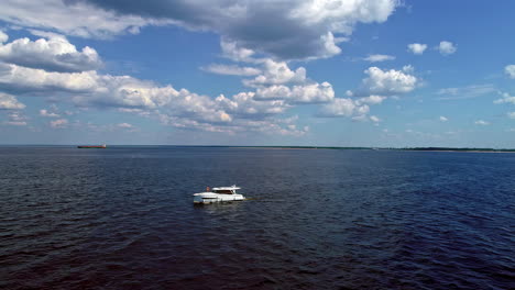 Aerial-drone-shot-over-motor-boat-moving-on-deep-blue-sea-at-daytime