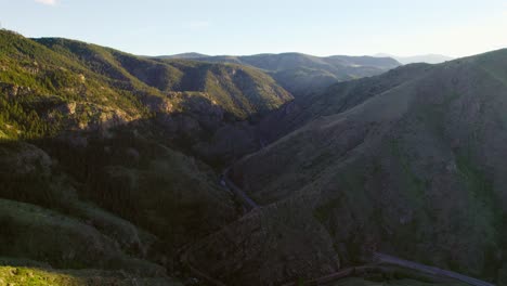 Aerial-Drone-Shot-Of-Shadowy-Mountain-Valley-During-Beautiful-Golden-Hour-Sunset