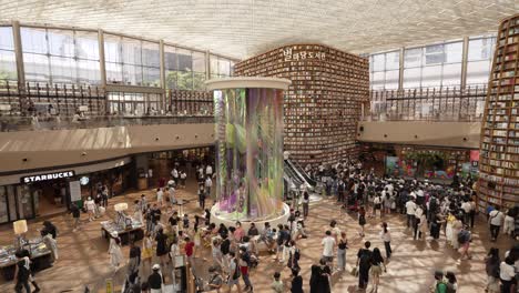 People-move-around-watching-and-choosing-books-in-Starfield-Library-in-Coex-Mall---panning-shot