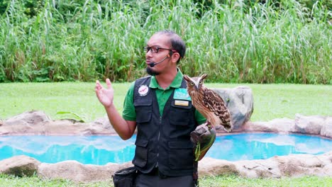 Guardián-Del-Zoológico-Y-Entrenador-Con-Búho-En-La-Mano-Explicando-Al-Público-Sobre-Los-Animales