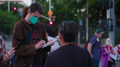 Ein-Weißer-Mann-Mit-Maske-Unterschreibt-In-Der-Innenstadt-Eine-Verzichtserklärung