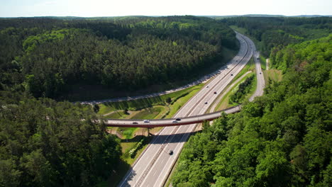 Beautiful-Aerial-View-of-Bridge-Intersection-and-Highway-traffic-in-Green-Forest-Countryside-area