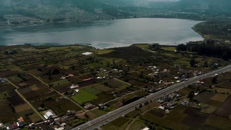 Abundant-Land-And-Borough-Of-San-Pablo-Del-Lago-With-Tranquil-Basin-Of-San-Pablo-Lake-Against-The-Uplands-Of-Inactive-Imbabura-Volcano-In-Otavalo,-Ecuador