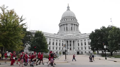 Edificio-Del-Capitolio-Del-Estado-De-Wisconsin-Con-Una-Banda-De-Música-Caminando-En-Un-Video-Estable