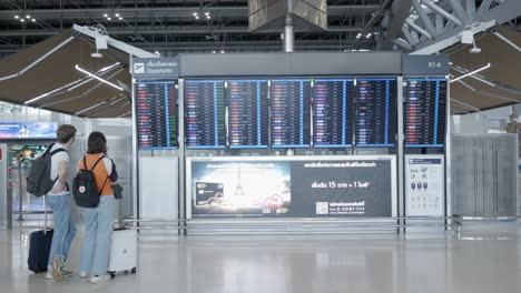 Personas-Revisando-El-Tablero-De-Información-De-Vuelos-Dentro-De-La-Terminal-De-Salida-Del-Aeropuerto-Aeropuerto-De-Suvannabhumi-País-De-Reapertura