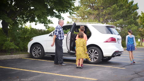 Happy-family-walking-towards-their-Car-in-a-parking-lot