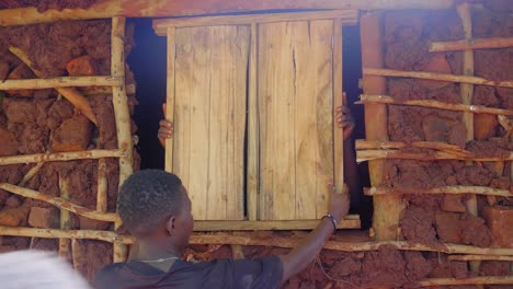 Africanos-Instalando-Una-Ventana-De-Madera-En-Una-Casa-De-Barro-De-Estilo-Tradicional-En-Una-Aldea-Africana-Rural