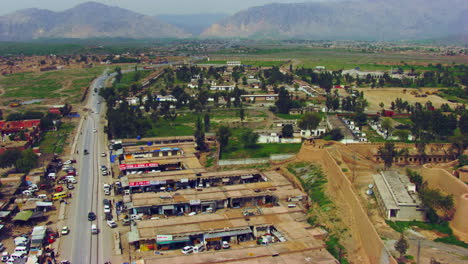 Peshawar,-Pakistan,-Aerial-view-of-busy-mountain-pass-connecting-the-Pak-Afghan-border-through-white-range-with-valley-of-Peshawar,-With-road-a-old-fortress-view