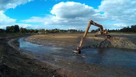 Bagger-Arbeiten-Mit-Eimern,-Um-Schlamm-Und-Schutt-Vom-Grund-Des-Entwässerten-Flusses-Zu-Entfernen