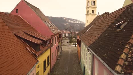 Un-Hermoso-Paisaje-Con-Un-Auto-Que-Pasa-Por-Una-Calle-De-Piedra-Y-Una-Iglesia-Al-Fondo-En-La-Famosa-Ciudad-Medieval-De-Sighisoara