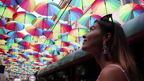 Mädchen,-Das-In-Ehrfürchtiger-Zeitlupe-Zu-Farbigen-Regenschirmen-Aufblickt