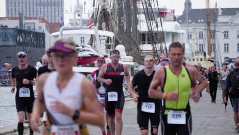 Tiro-De-Trípode-En-Cámara-Lenta-Con-Enfoque-Fijo-De-Hombres-Y-Mujeres-Corriendo-A-Lo-Largo-Del-Puerto-De-Copenhague-Durante-El-Kmd-Ironman-Copenhagen-2018