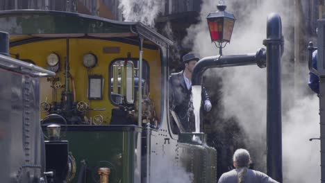 Young-man-filling-water-into-steam-locomotive-boiler-Blonay-Chamby-museum-track,-Switzerland