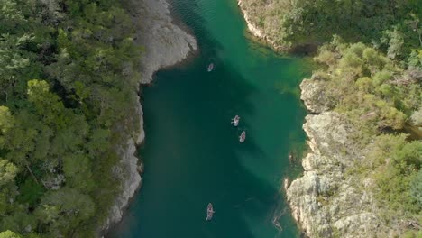 Slowmo---Menschen-Auf-Kajakfahrt-Paddelbooten-Durch-Canyon-Am-Pelorus-River,-Neuseeland-Mit-Einheimischen-Wäldern-Und-Felsbrocken---Luftdrohne