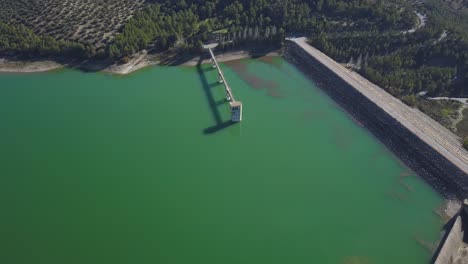 Luftaufnahme-Eines-Großen-Stausees-Mit-Kontrollturm-Und-Brücke-Im-Süden-Spaniens