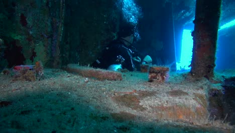 Diver-ascends-through-shipwreck-hatch