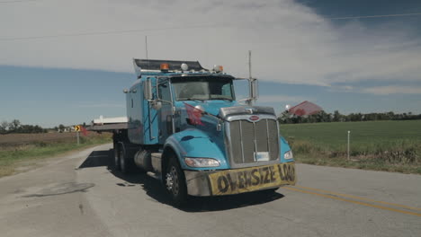 Oversize-load-truck-parked-by-side-of-the-road-with-flags