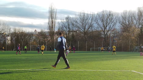 Portero-Pateando-Una-Pelota-A-Través-De-Un-Campo-De-Fútbol-A-Sus-Compañeros-De-Equipo