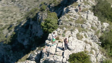 Luftbogenaufnahme-Von-Zwei-Freunden,-Die-Mit-Ihren-Handys-Fotos-Von-Der-Spektakulären-Aussicht-Von-Den-Bergen-In-Spanien-Machen