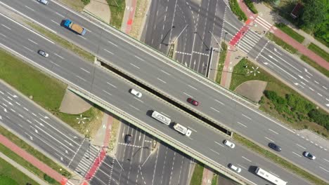 Top-view-over-the-highway,-expressway-and-motorway,-Aerial-view-interchange-with-car-driving-down-the-highway