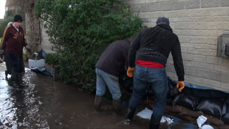 UK-Februar-2014---Anwohner-Arbeiten-Zusammen,-Um-Sandsack-Verteidigungen-Neben-Häusern-Zu-Bauen,-Um-Steigende-Hochwasser-Während-Der-Flut-Von-Somerset-Levels-Zu-Stoppen