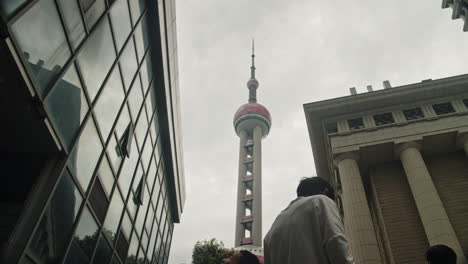 Time-lapse-of-Oriental-Peral-TV-Tower,-on-a-cloudy-day,-with-tourists-passing-by,-Shanghai,-China