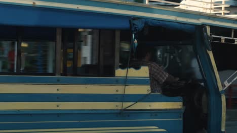 Bus-driver-in-Phuket-driving-pass-through-street-in-Thailand-during-the-day