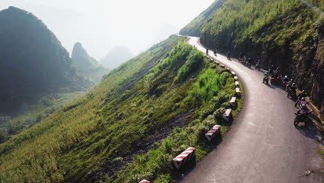 Drone-view-showing-a-group-of-motorcyclists-preparing-to-continue-their-ride-together-along-the-Ma-Pi-Leng-Pass-in-the-late-afternoon