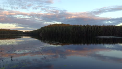 Stunning-drone-footage-of-a-calm-lake-by-dusk-in-the-borealis-wilderness