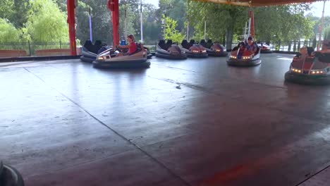 Coches-Eléctricos-En-El-Carrusel,-Como-Niños,-En-El-Parque-Del-Centro