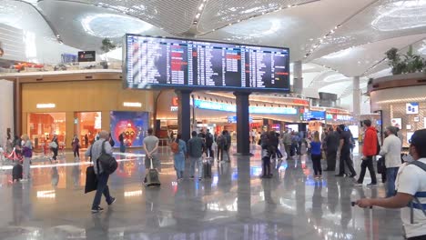 Gente-Mirando-El-Tablero-De-Llegadas-Y-Salidas-En-El-Nuevo-Aeropuerto-De-Estambul,-Turquía