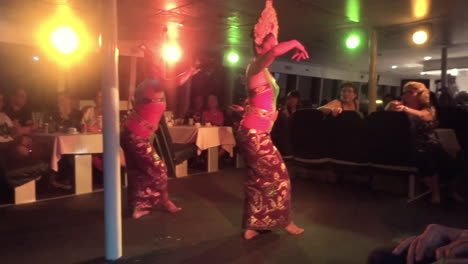 Dos-Mujeres-Realizando-Una-Danza-Tradicional-Dentro-De-Un-Crucero-Con-Una-Audiencia-En-Bali,-Indonesia