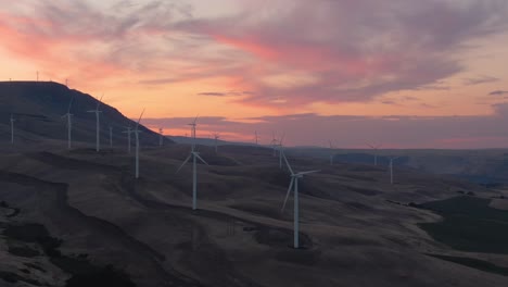 Aerial-Landscape-View-of-Wind-Turbines-on-a-Windy-Hill-during-a-colorful-sunrise