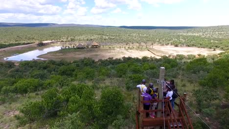 Toma-Aérea-De-Un-Grupo-De-Amigos-Comenzando-A-Hacer-Tirolesa-En-Lobatse,-Botswana