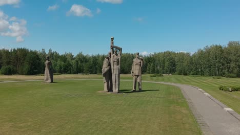 Tiro-Largo-Aéreo-De-Estatuas-Colosales-En-El-Memorial-De-Salaspils,-Letonia