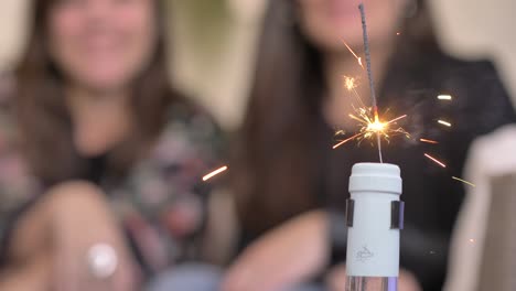 Female-friends-watching-sparkler-in-wine-bottle-cork